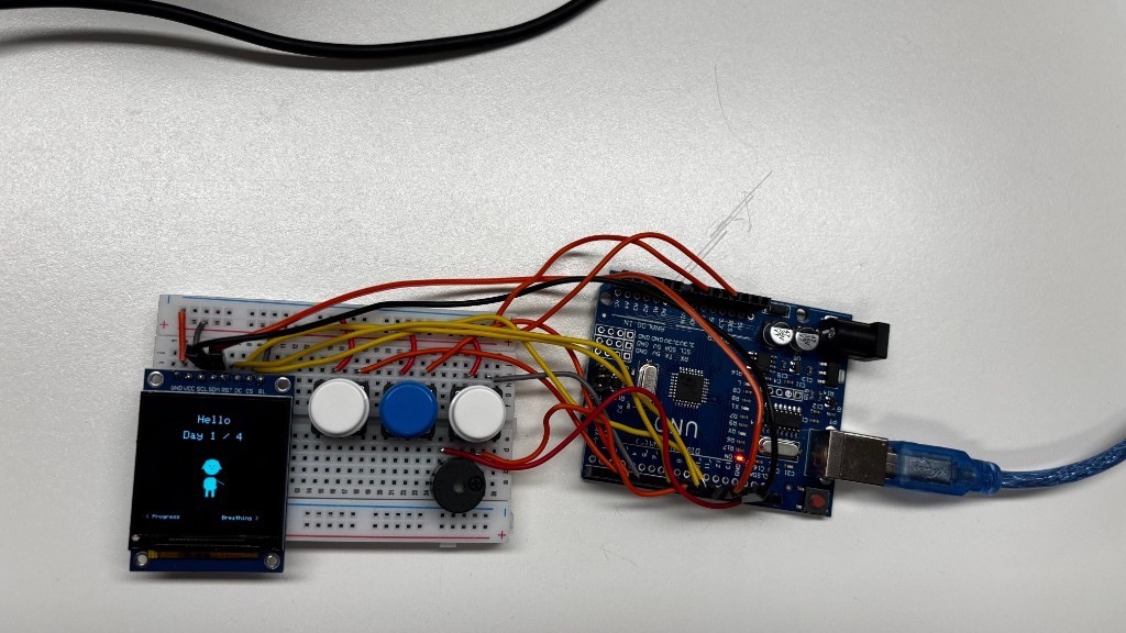 Arduino Uno prototype with OLED display, buttons, and buzzer on a breadboard
